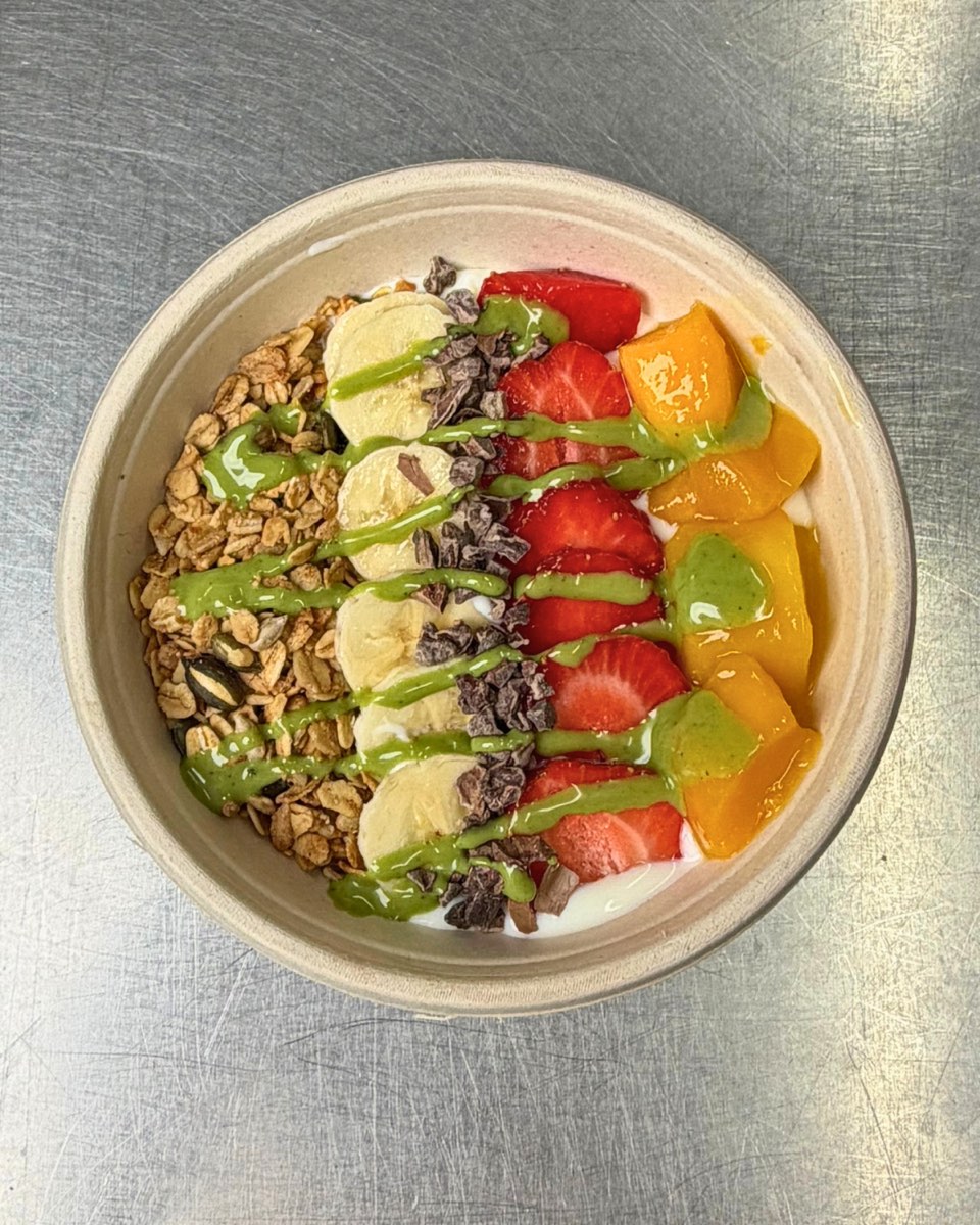 A built-to-order bowl with banana, strawberries, mango and a pistachio drizzle