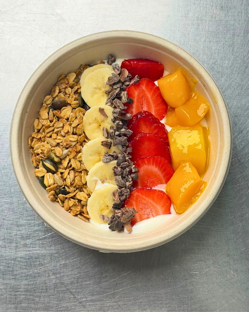 A built-to-order bowl with banana, strawberries, mango and cacao nibs