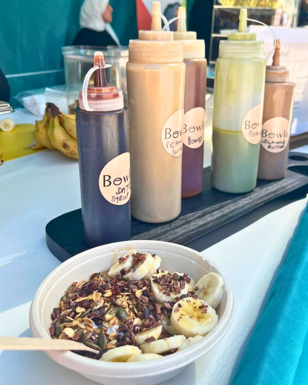 The drizzle bottles lined up beside a finished bowl
